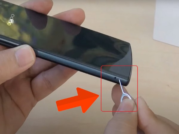 Dùng que chọc vào khe hở hoặc nhấn tay vào một điểm trên nắp lưng để bật ra